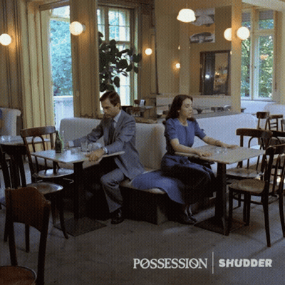 Man And Woman At Restaurant With Possession Shudder GIF