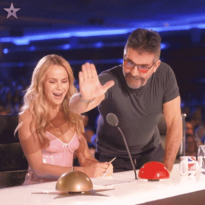 Man And Woman At Table With Microphone And Red Button GIF