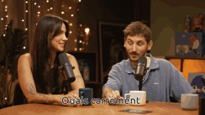 Man And Woman At Table With Microphones Ouais Carrément GIF
