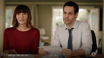 Man And Woman At Table With NBC Logo GIF