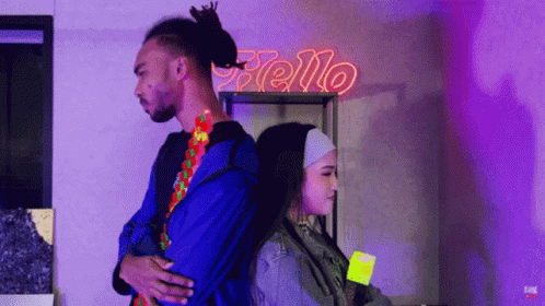 Man And Woman Back To Back Under Neon Sign Saying Hello GIF