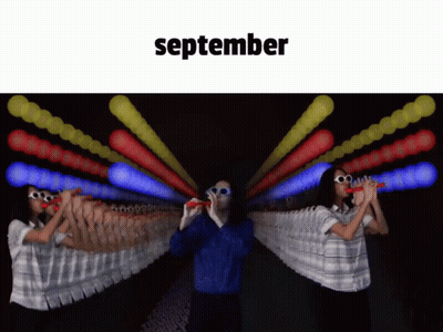 Man And Woman Blowing Bubbles In Front Of September Sign GIF