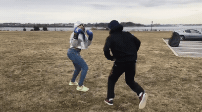 Man And Woman Boxing In Field With Car GIF