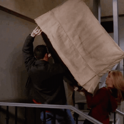 Man And Woman Carrying Furniture Up Staircase GIF