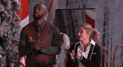 Man And Woman Clapping In Front Of Candy Cane Display GIF