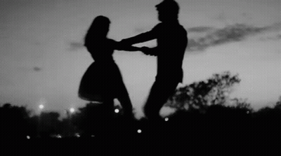 Man And Woman Dancing At Sunset In Park GIF