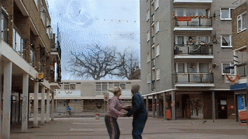 Man And Woman Dancing In Courtyard GIF