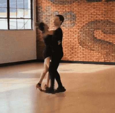 Man And Woman Dancing In Front Of Brick Wall GIF