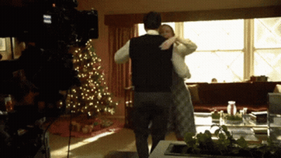 Man And Woman Dancing In Front Of Christmas Tree GIF