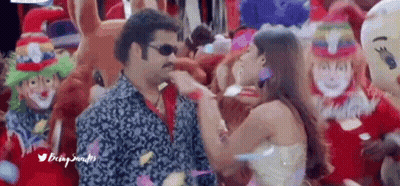 Man And Woman Dancing In Front Of Clowns And Balloons GIF