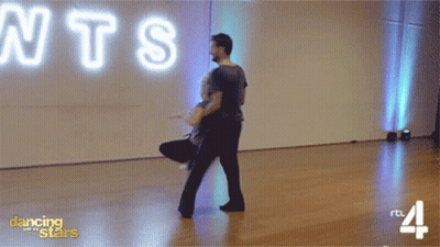 Man And Woman Dancing In Front Of Neon Sign Saying NTS GIF