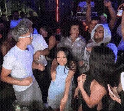 Man And Woman Dancing In Front Of Wall Of Wheels GIF