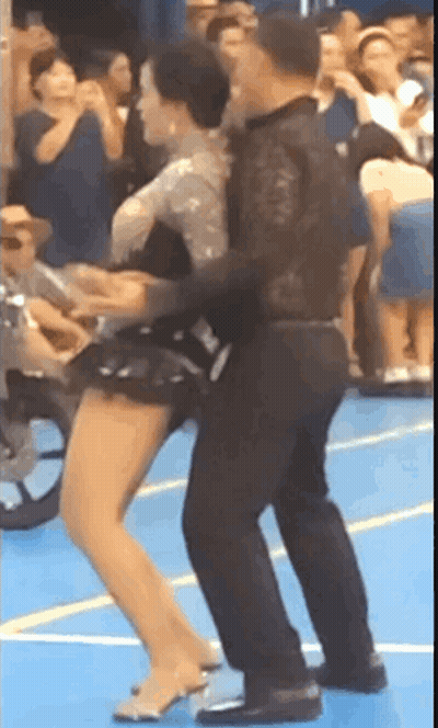 Man And Woman Dancing On Blue Floor With Crowd GIF