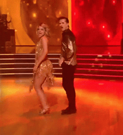 Man And Woman Dancing On Red-Lit Stage GIF