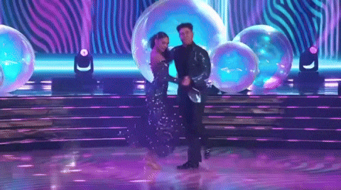 Man And Woman Dancing On Stage With Bubbles GIF