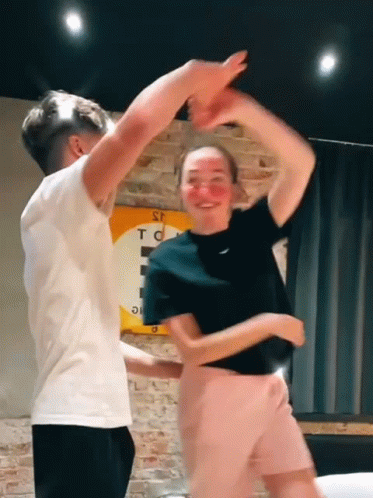 Man And Woman Dancing Under S.T.C. Sign GIF