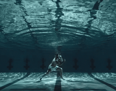 Man And Woman Dancing Underwater With Letter T GIF