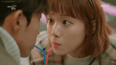 Man And Woman Drinking Through Straws GIF
