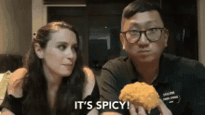 Man And Woman Eating Fried Chicken Saying It's Spicy GIF