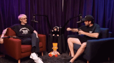 Man And Woman Fist Bumping In Front Of Stuffed Monkey GIF