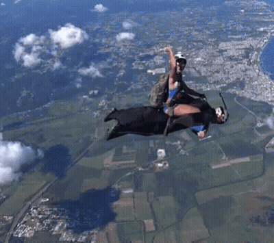 Man And Woman Flying With Parachute GIF