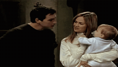 Man And Woman Holding Baby With Pacifier GIF