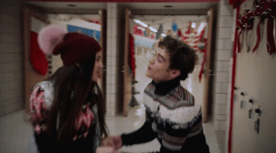 Man And Woman Holding Hands In Christmas Hallway GIF