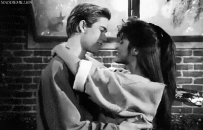 Man And Woman Hugging And Kissing In Front Of Brick Wall GIF