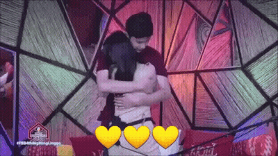 Man And Woman Hugging In Front Of Colorful Background GIF