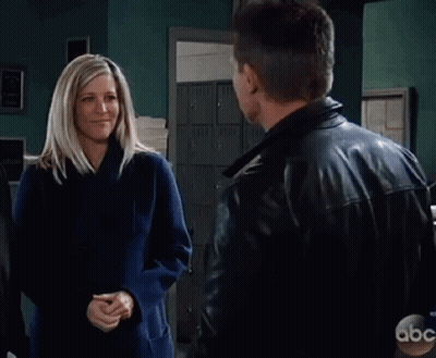 Man And Woman Hugging In Front Of Exit Sign GIF