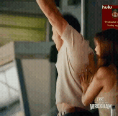 Man And Woman Hugging In Front Of Wrexham Sign GIF