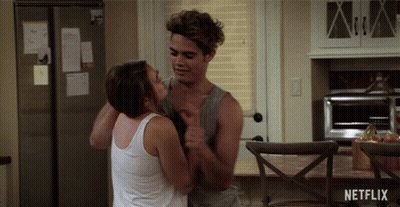 Man And Woman Hugging In Kitchen With Netflix Logo GIF