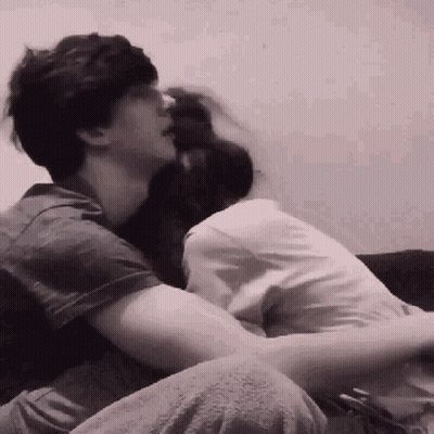 Man And Woman Hugging On Couch In Black And White GIF