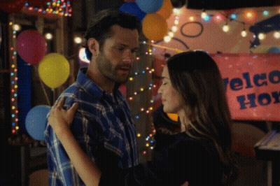 Man And Woman Hugging Welcome Home Sign GIF