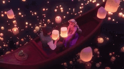 Man And Woman In Boat Looking At Floating Lanterns GIF