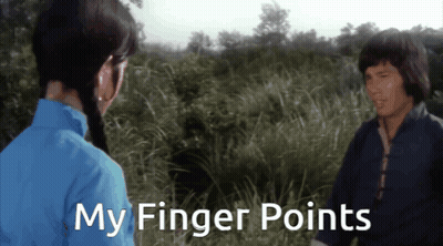 Man and Woman in Field Saying My Finger Points