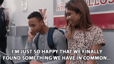 Man And Woman In Front Of Art Sign GIF