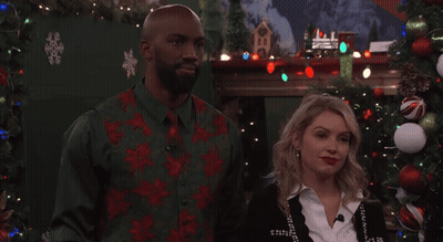 Man And Woman In Front Of Christmas Tree And Fireplace GIF