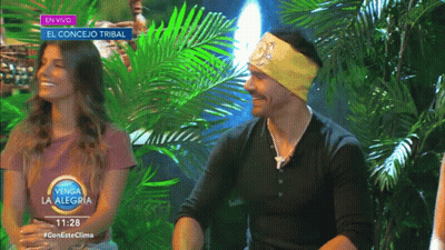 Man And Woman In Front Of En Vivo Sign GIF