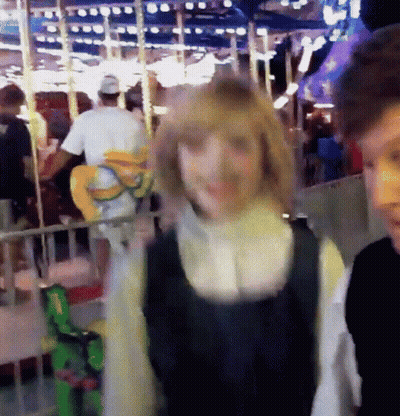 Man And Woman In Front Of Ferris Wheel GIF