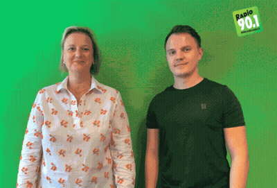 Man And Woman In Front Of Green Background Saying Radio 90.1 GIF
