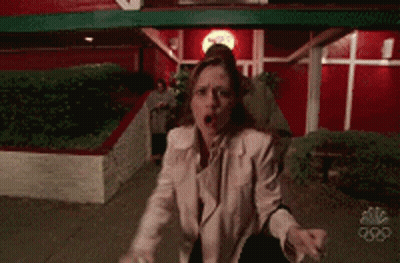 Man And Woman In Front Of Red NBC Building GIF