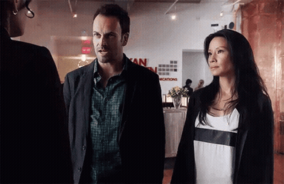 Man And Woman In Front Of Vacations Sign GIF