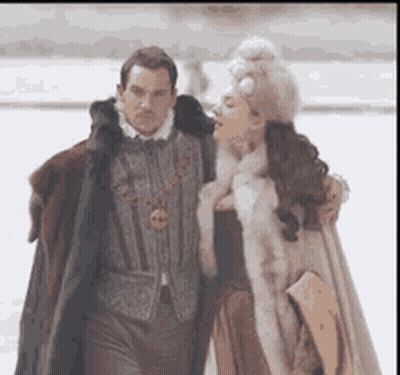 Man And Woman In Fur Coats Walking In Snow GIF