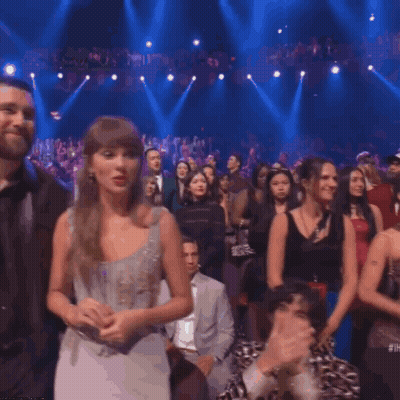 Man And Woman In Headphones With New Heights Sign GIF