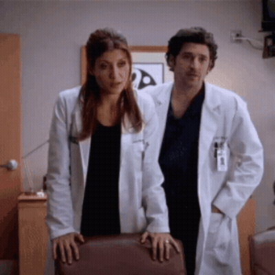 Man And Woman In Lab Coats Standing Together GIF