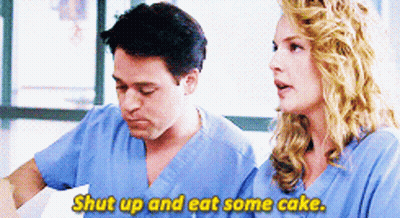 Man And Woman In Scrubs Talking Woman Says Shut Up And Eat Some Cake GIF