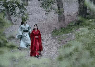 Man And Woman In Traditional Costume Walking Through Forest GIF