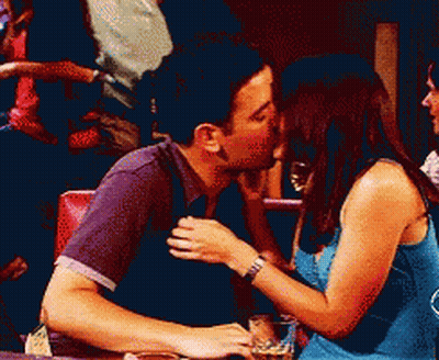 Man And Woman Kissing At Table GIF