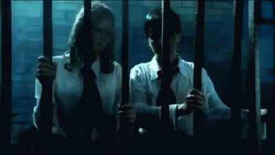 Man And Woman Kissing Behind Bars GIF